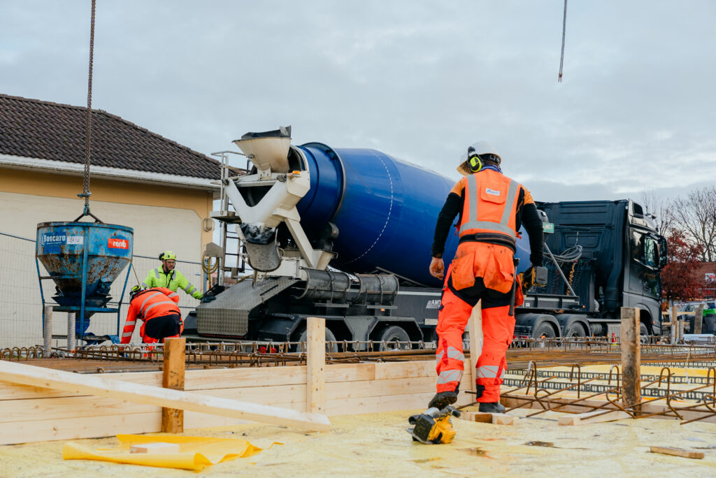 Bygningsarbeider i verneutstyr ved betongbil under støpearbeid på byggeplass hos Ecosør