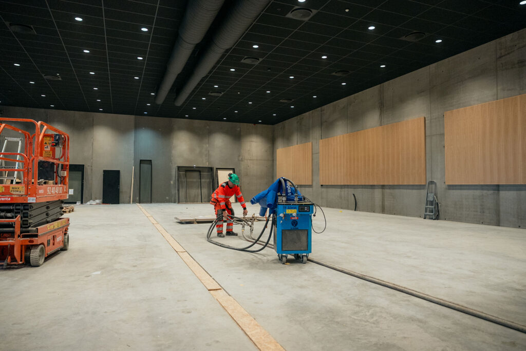 Etterbehandling av betonggulv på byggeplass hos Ecosør